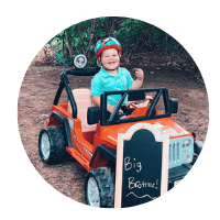 Happy boy Ollie riding his toy truck